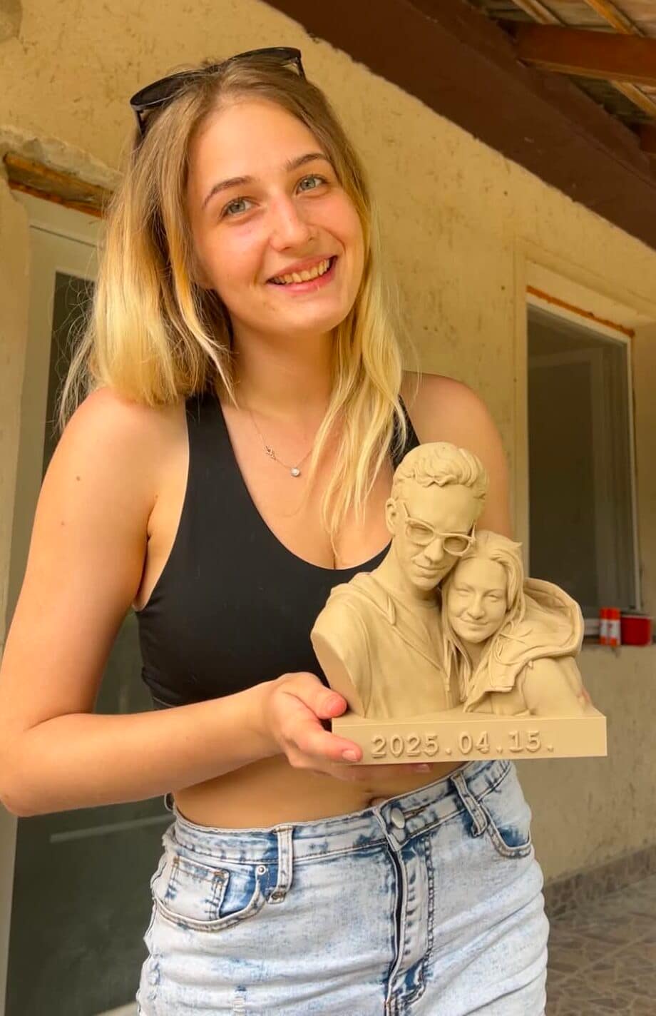 Vásárló egy fénykép alapján készült, személyre szabott páros 3D nyomtatott mellszobrot tart a kezében